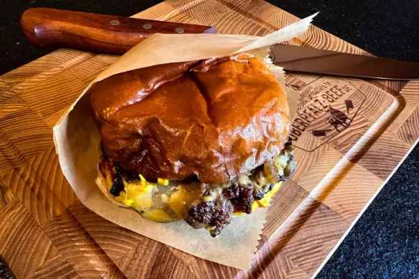 Saftiger Cheeseburger Rolle auf Holzbrett, bereit zum Genuss.