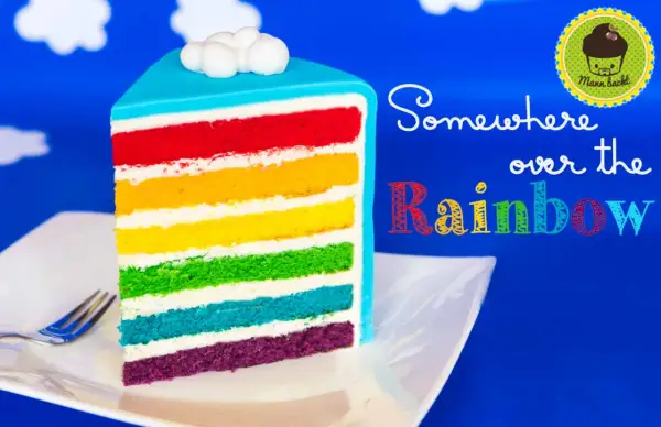 Ein Stück regenbogen kuchen mit bunten Schichten und Wolken-Topping.