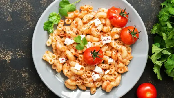 Feta Pasta aus dem Ofen: cremige Makkaroni mit geschmolzenem Feta, Kirschtomaten und frischer Petersilie.